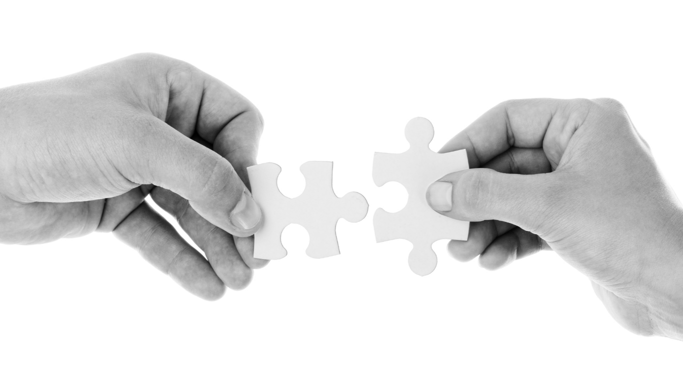 Two hands each holding a piece of puzzle that integrates with the other - Sync Vista Digital Marketing HR integration